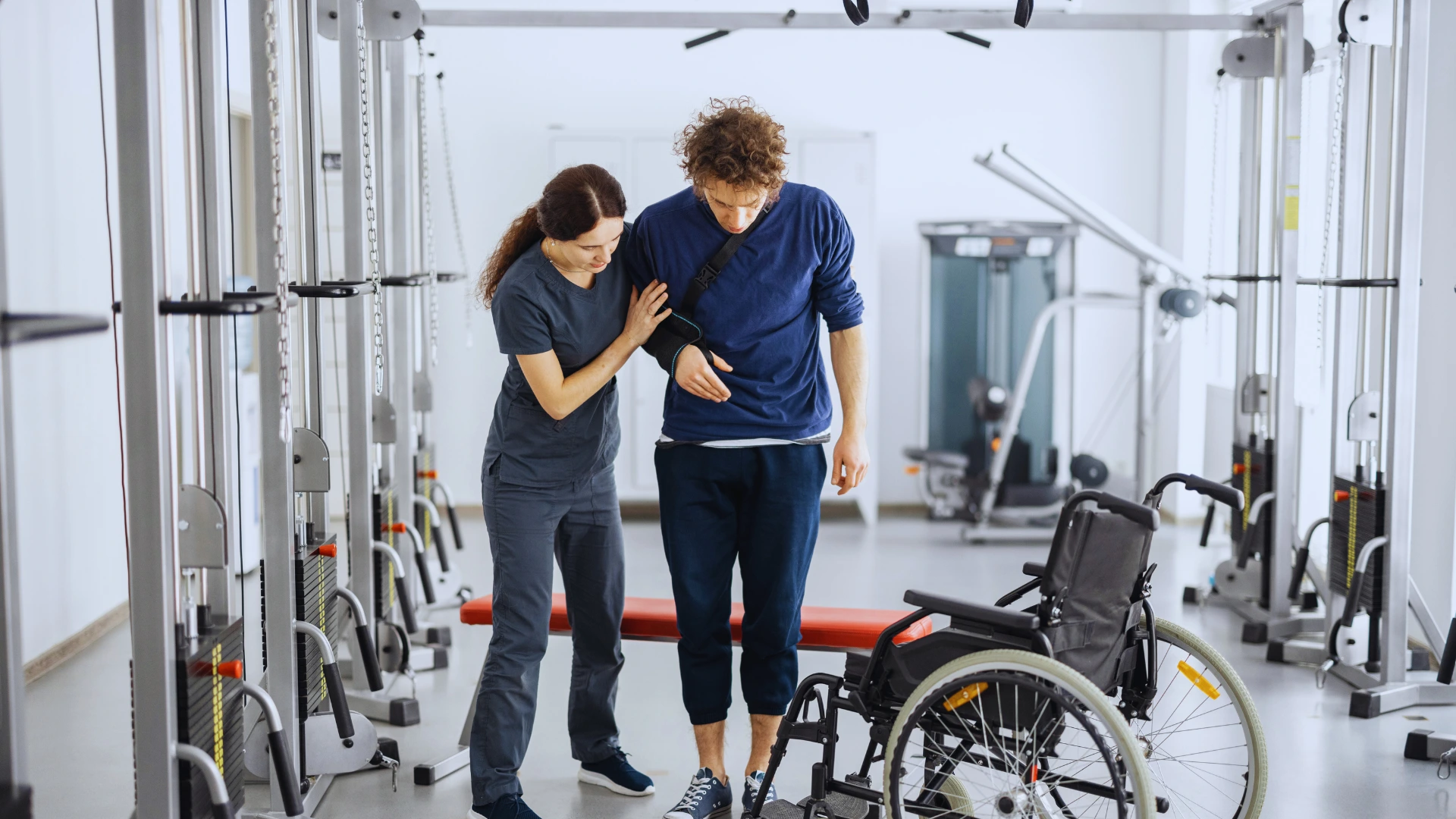 therapist-helping-man-recover-in-physical-therapy-gym